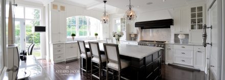 White kitchen with central island and built-in cabinets.