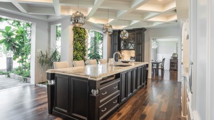 Elegant Kitchen equipped with dark cabinets and central island.