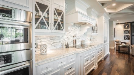 Furnished kitchen with white cabinets, light countertops, and elegant elements.