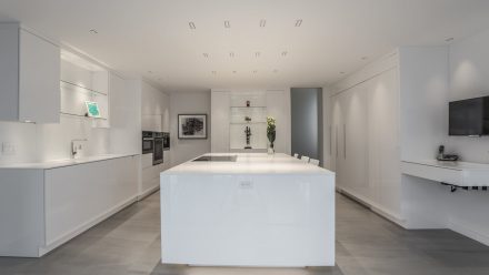 White kitchen with white worktop and backsplash in a modern home.