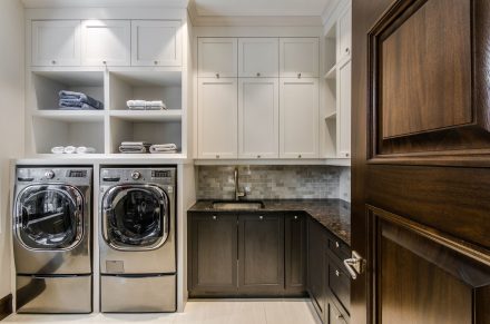 Sleek design of a contemporary laundry room with dark cabinets.