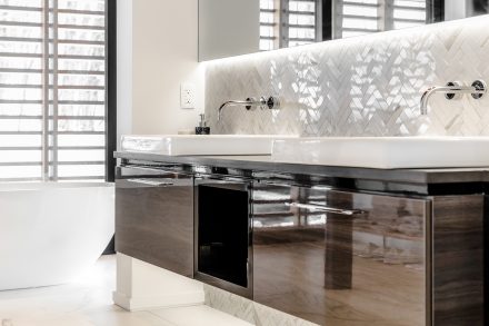 Stunning contemporary white bathroom with chevron patterned backsplash.